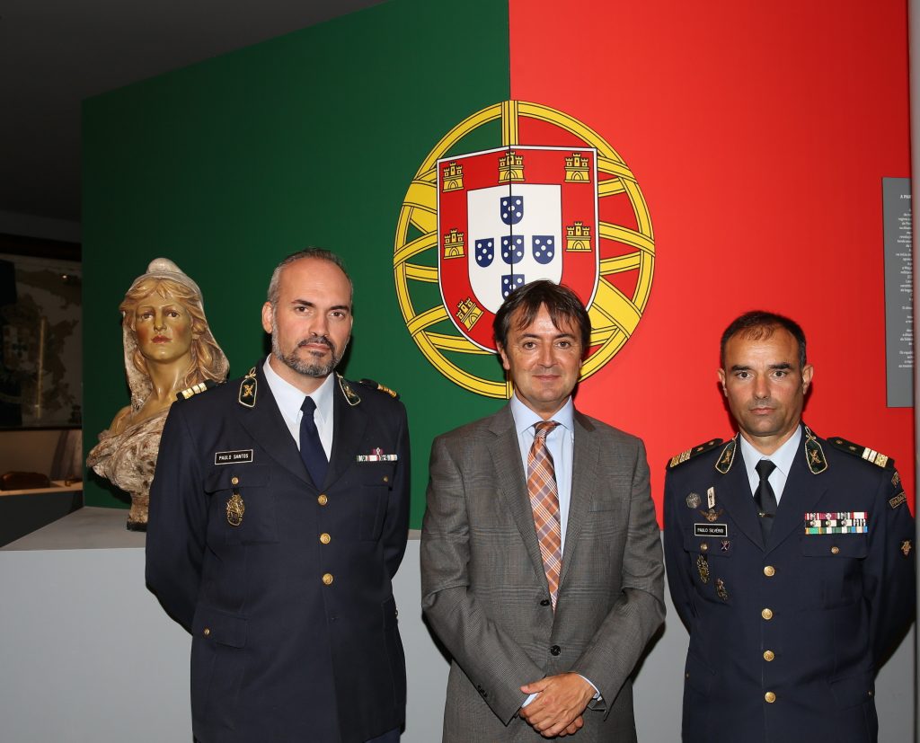 El Teniente-Coronel Paulo Jorge Alves Silvério (Jefe de la División de Planificación Estratégica y Relaciones Internacionales) a la derecha de la imagen, el Teniente Coronel Paulo Jorge Soares dos Santos (Jefe de la División de Contrainformación y Seguridad. Responsable del Grupo de Trabajo de Ciberseguridad) y Jorge Flore en el interior del Museo de la GNR, con el escudo de Armas de Portugal.